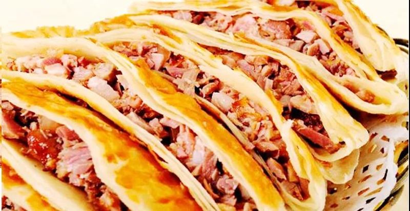 饼 皮面金黄、圆如满月、层层分离、外酥里嫩、滋味浓香、回味悠长。其食用时辅以甜面酱、葱丝、再喝上一碗小米绿豆大枣粥更增食趣。